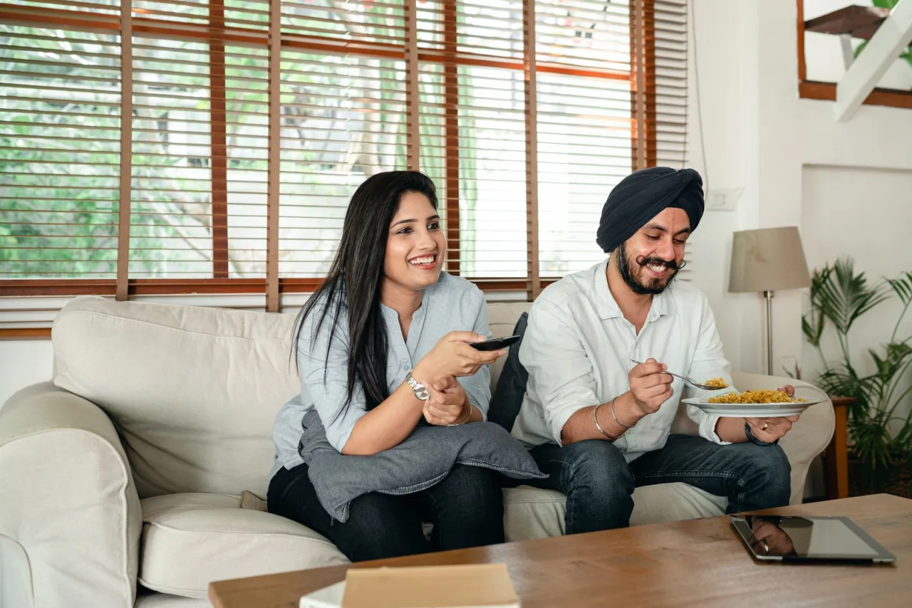 A couple relaxing at home and watching television.