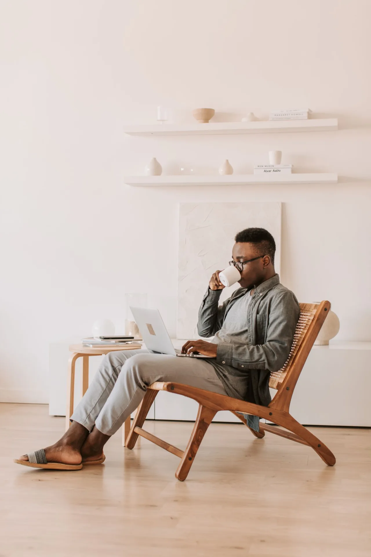 A reader browsing on a laptop with a coffee.